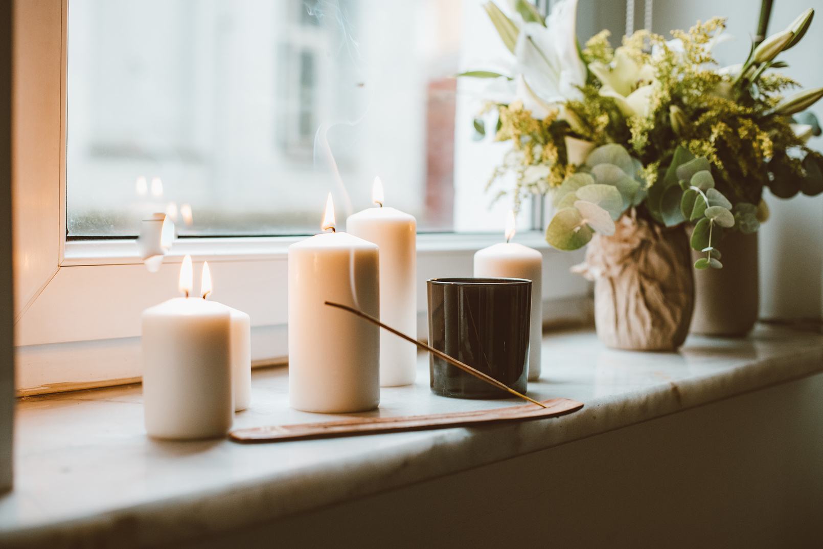 Candles and Incense Burning on Window Sill and Green Bouquet